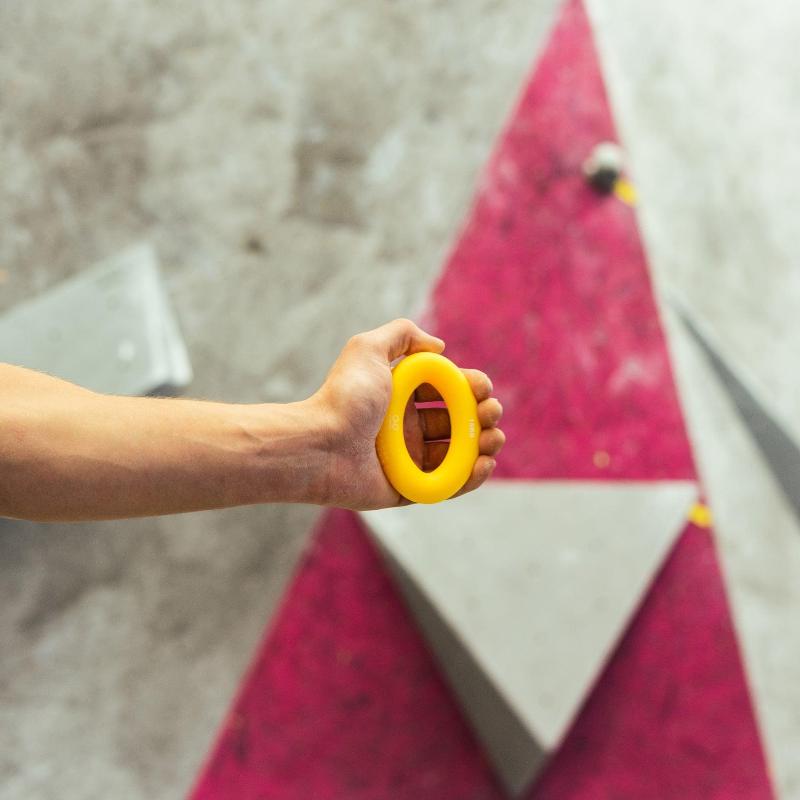 Man pinching on rubber rings for climbing warm up tools
