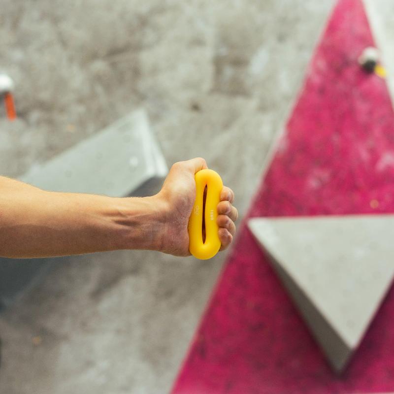 Man pinching on rubber rings for climbing warm up tools