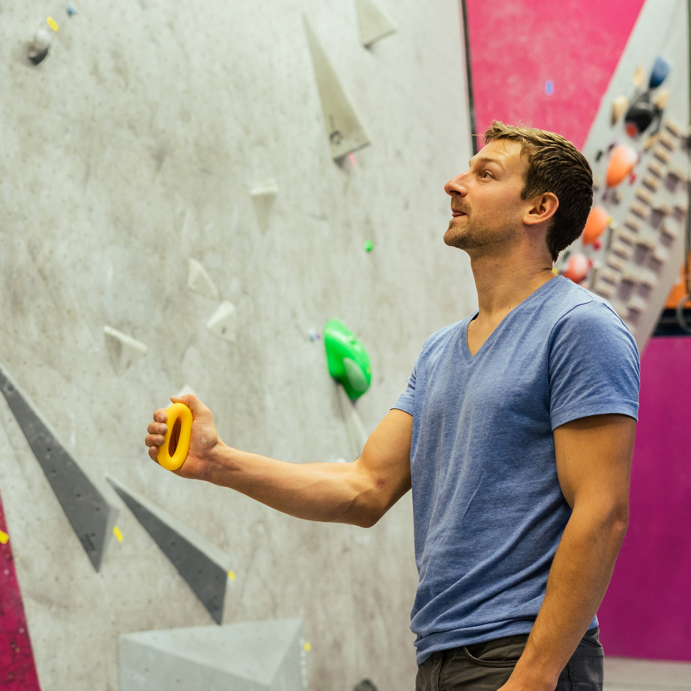 Man pinching on rubber rings for climbing warm up tools